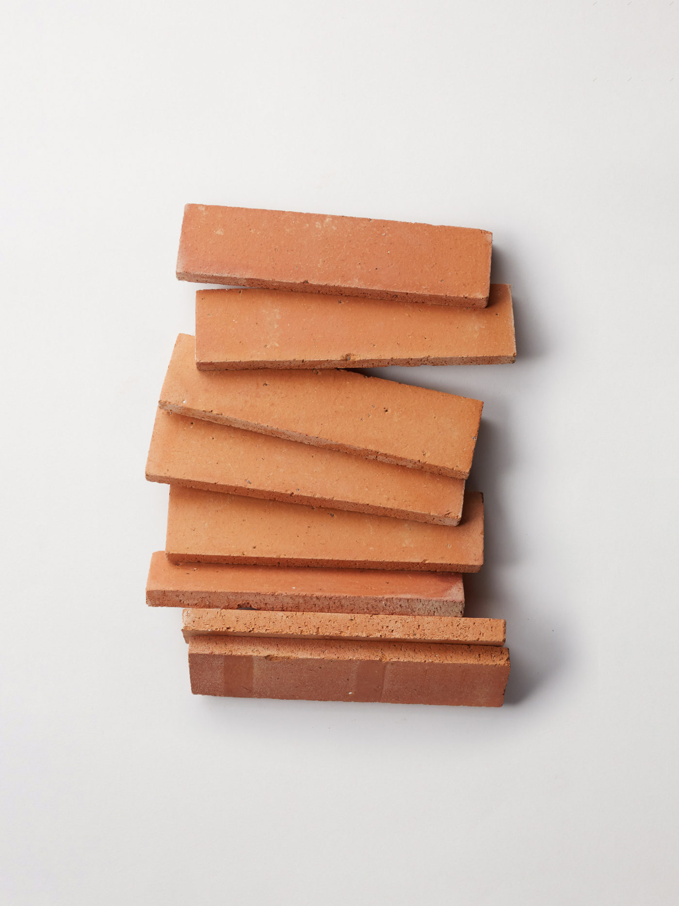 a stack of red terracotta tiles on a white background.