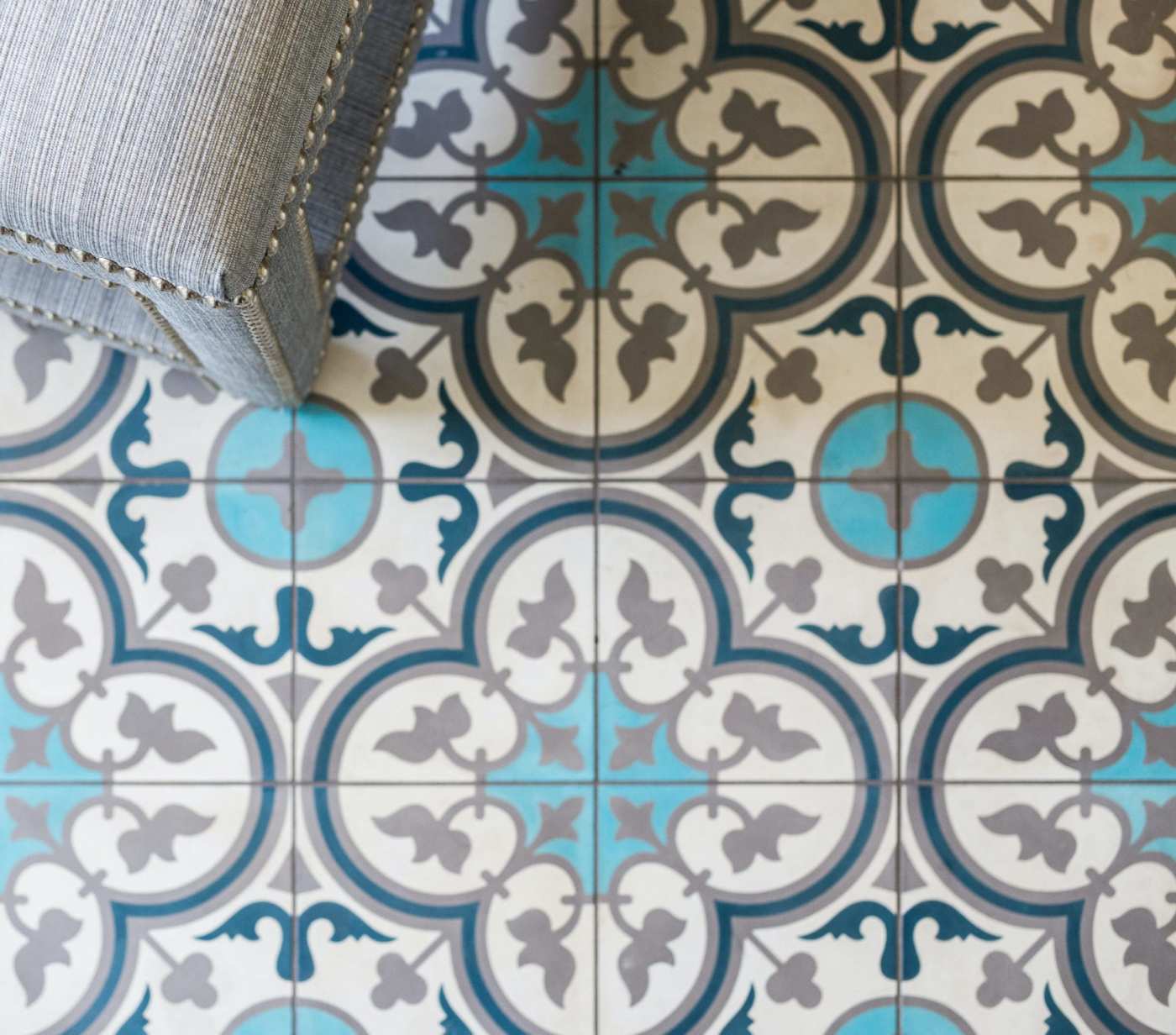 a blue and white tiled floor with a chair on it.