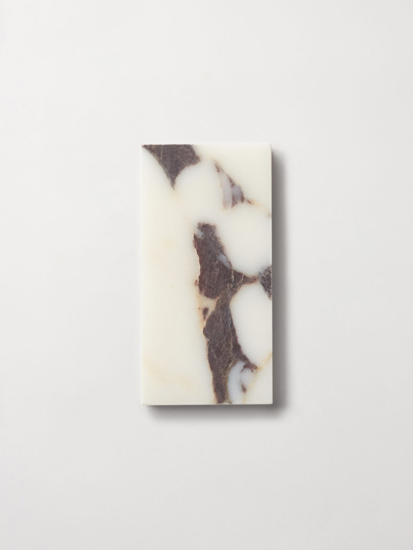 a white and brown marble tile on a white surface.