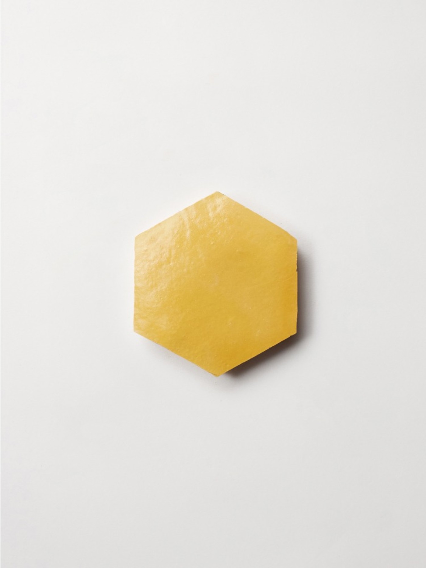 a yellow hexagonal tile on a white background.