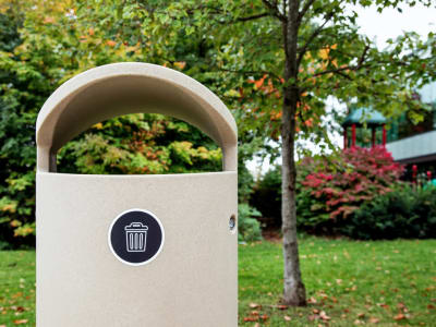 beige waste bin with canopy lid outdoors at community park