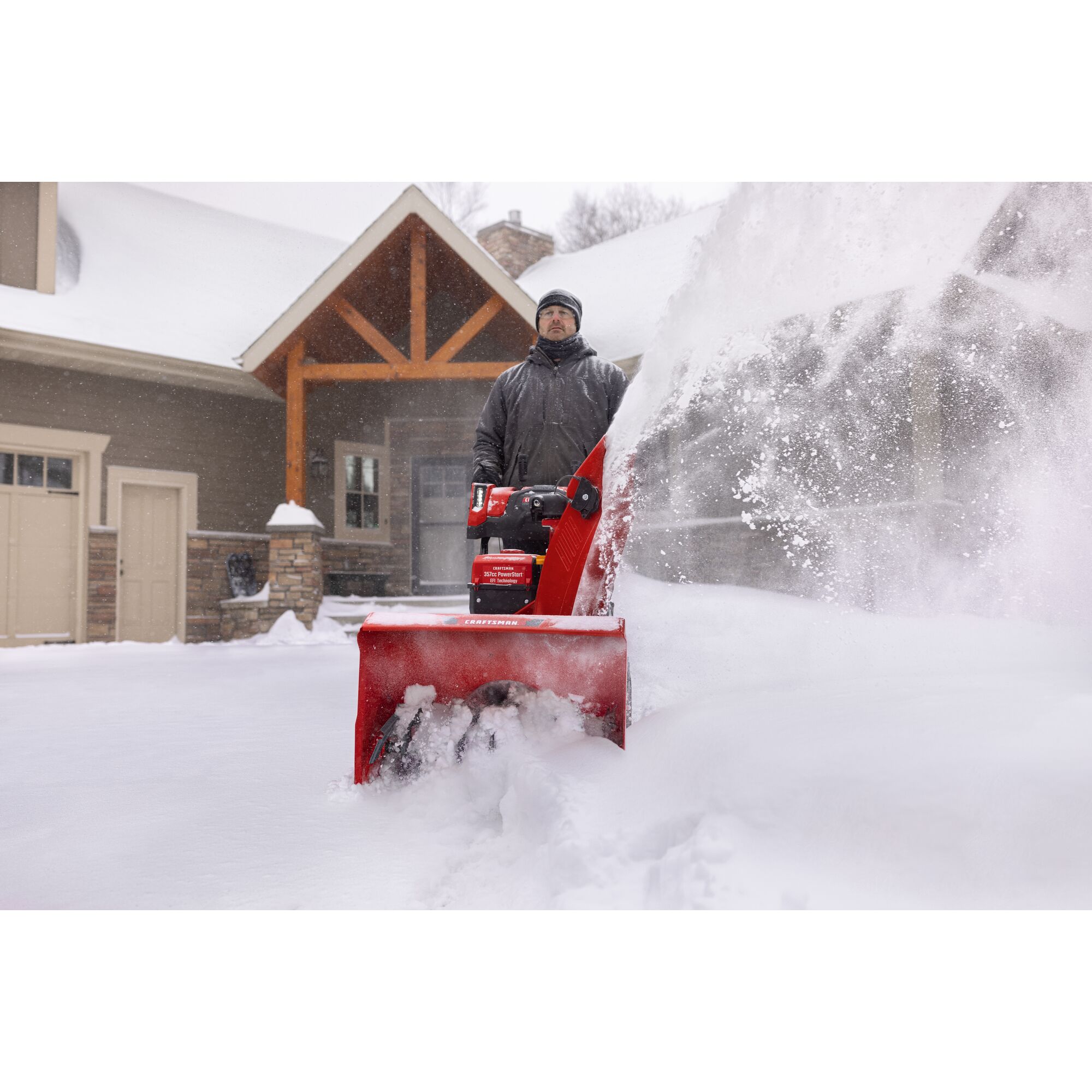 CRAFTSMAN Performance 26 Track Snowblower clearing snow off driveway green house in background
