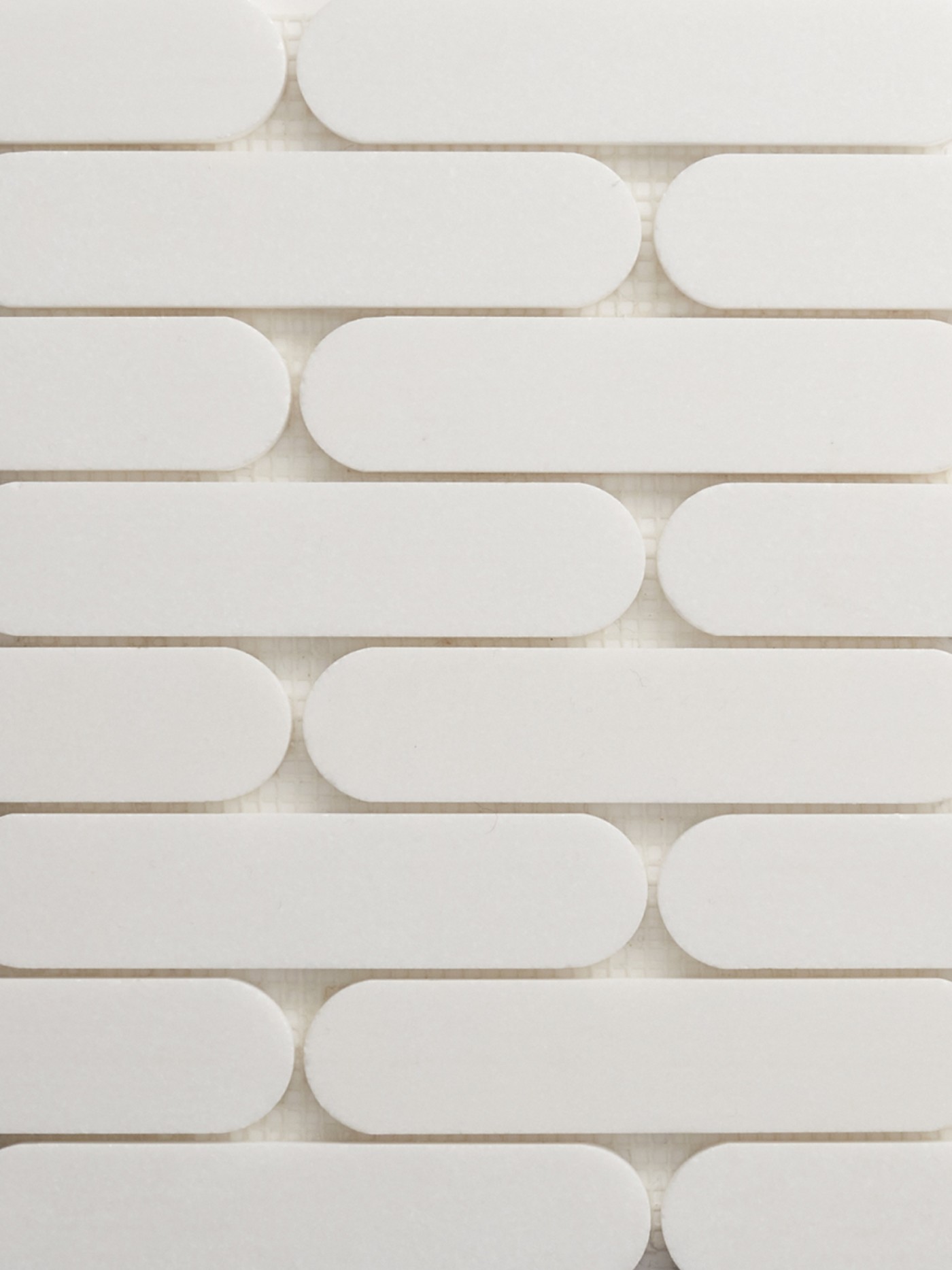 white, oval natural stone tiles arranged in a pattern.