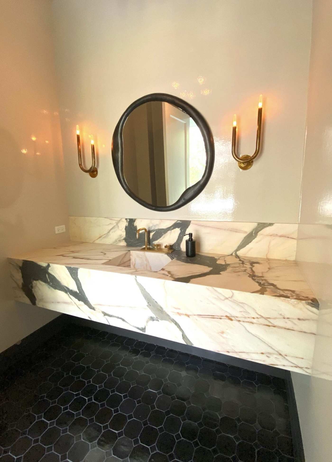 a bathroom with marble counter tops and a mirror.