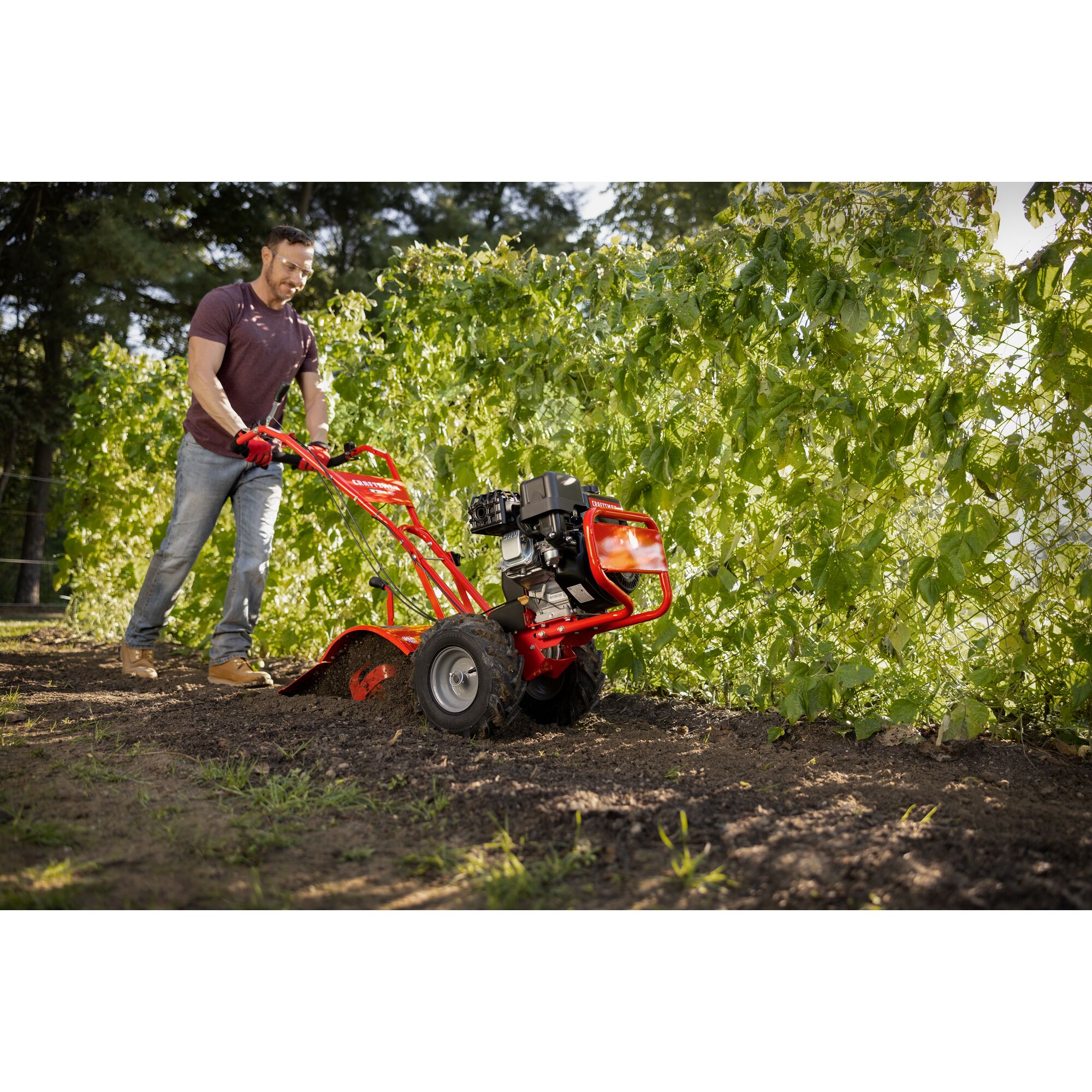 CRAFTSMAN 16-in. 208cc Gas Rear Tine Tiller tilling garden area with trees in background