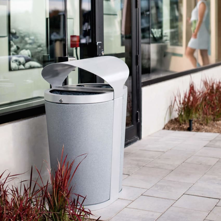 metal outdoor recycling and waste container with metal canopy top to keep contents dry sitting outside a retail business