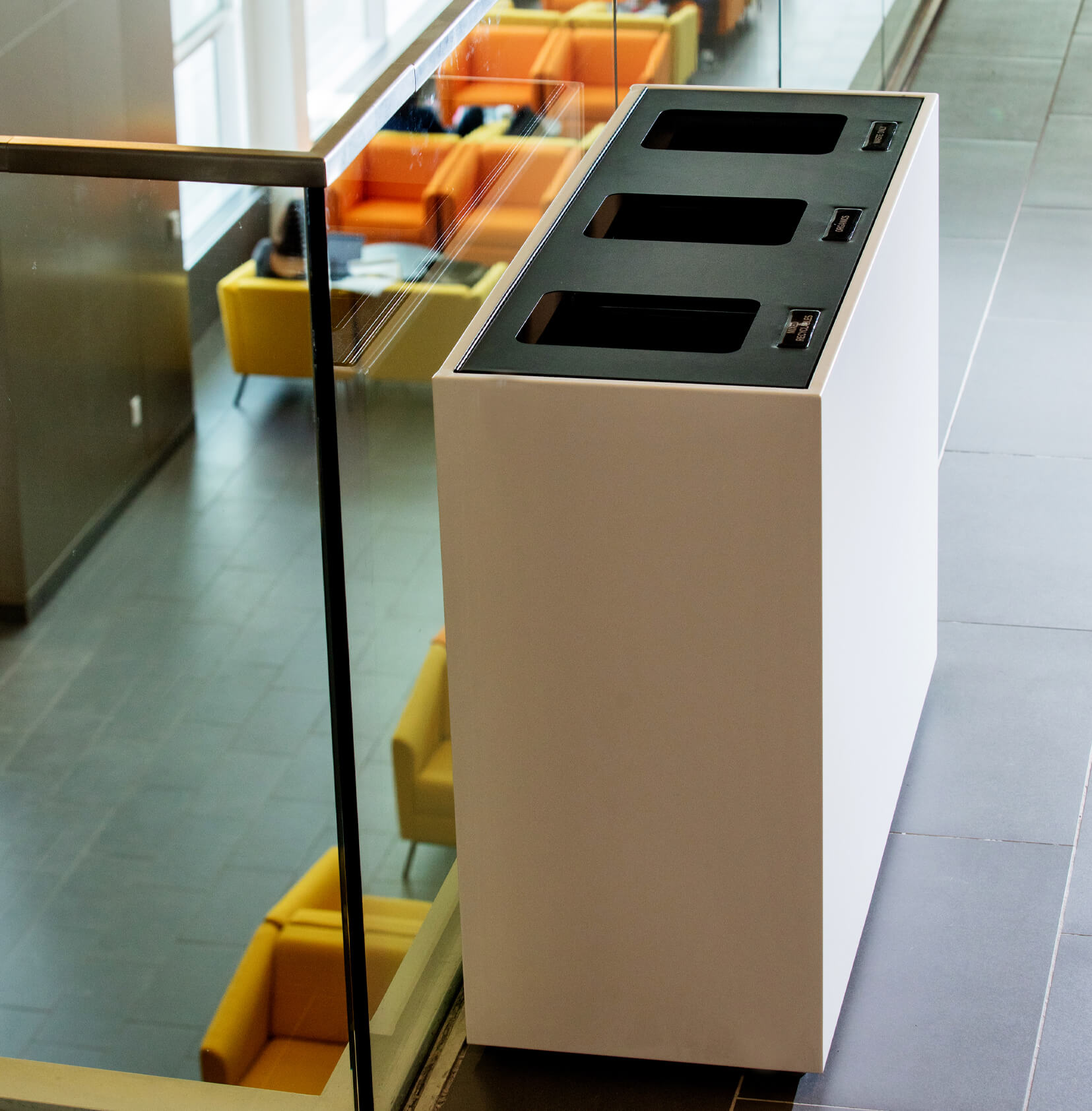 high-end waste and recycling container made from durable powder coated steel with a black hinged lid at a university campus