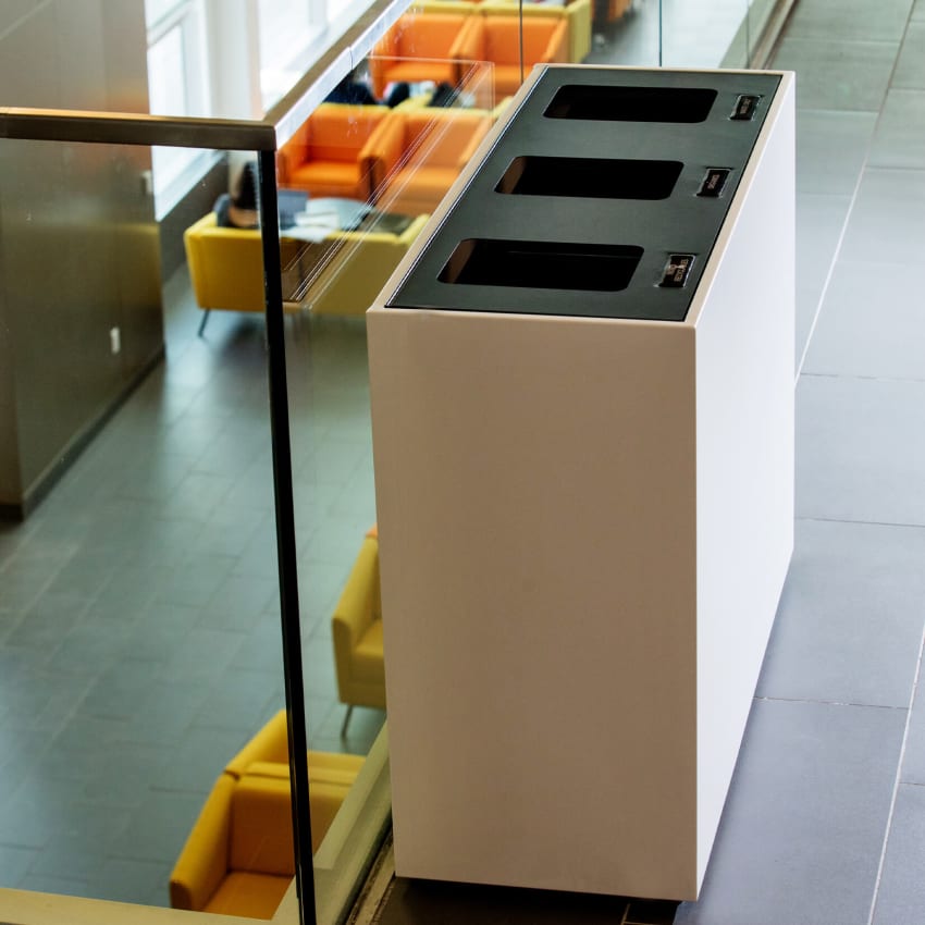 high-end waste and recycling container made from durable powder coated steel with a black hinged lid at a university campus