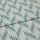 Folded woven fabric with teal ikat-like diagonal stripes and subtle vertical ribbing — folded once, lying flat on a neutral surface, close-up, soft even lighting.