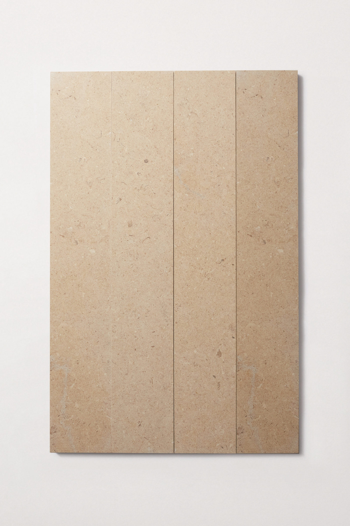 Four tan colored limestone rectangular tiles laid out lengthwise in a row on a white background.