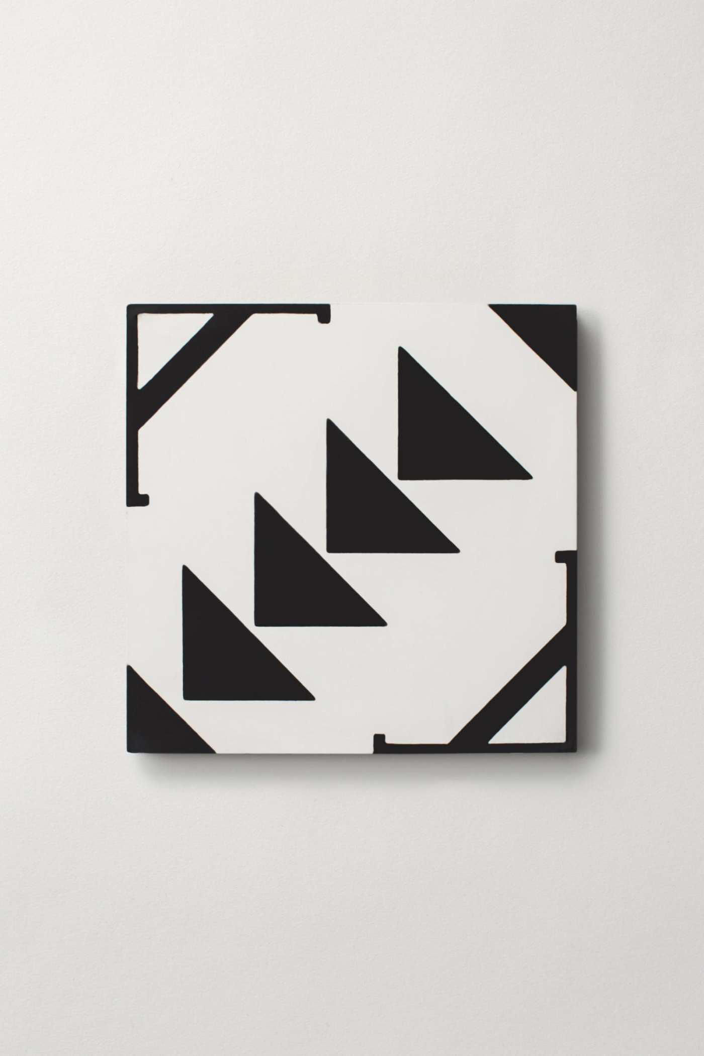 a black and white tile with a geometric design on a white surface.