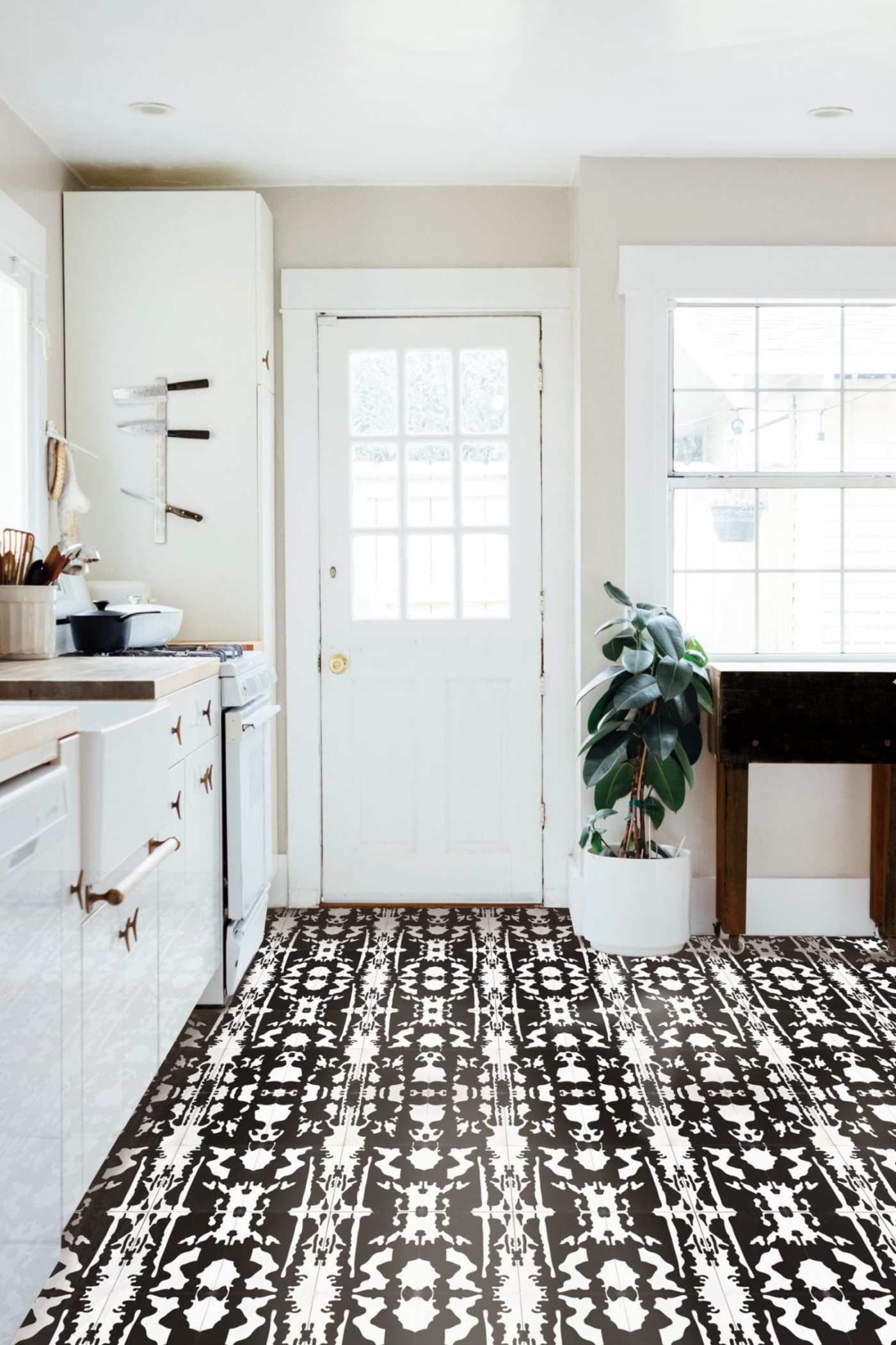 a kitchen with a black and white tile floor.