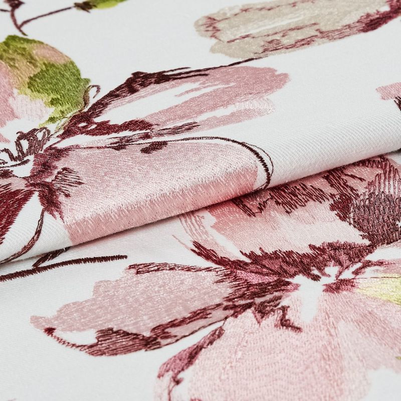 Embroidered floral fabric, white base with pink and burgundy satin-like stitching, folded to reveal raised texture and sheen; close-up studio-lit detail emphasizing pattern and weave.
