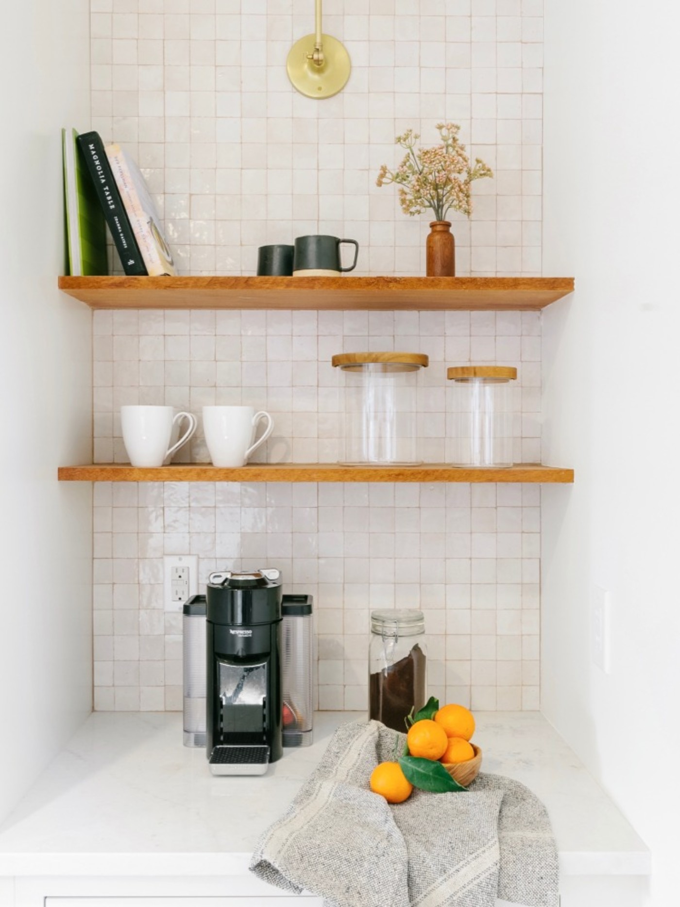 a small kitchen with a coffee maker and mugs.