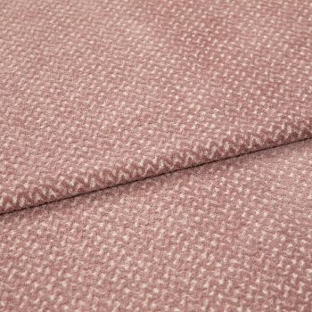 Textured woven upholstery fabric, dusty rose with small creamy fleck pattern, folded in two layers; lying flat on a neutral surface under soft, diffuse studio lighting for detail display.