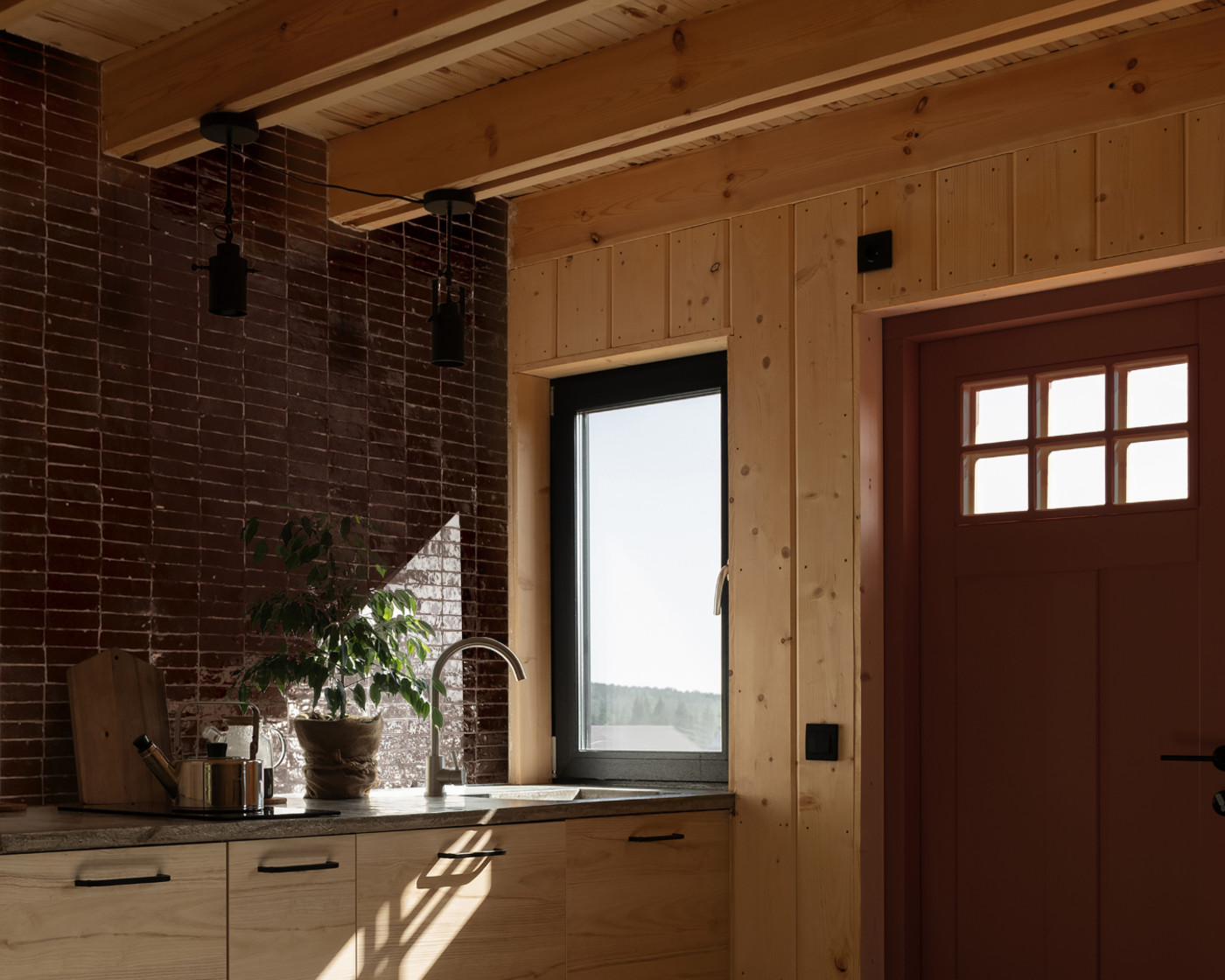 a kitchen with a window and a potted plant.