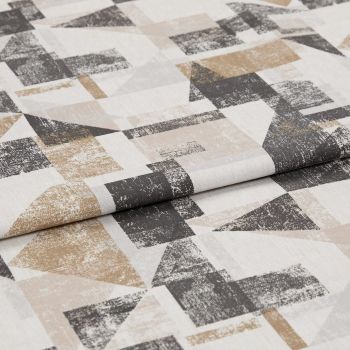 Folded textile sample with distressed geometric printâ€”overlapping triangles and rectangles in beige, tan and charcoal on off-whiteâ€”laid flat with a visible central fold under soft studio lighting.