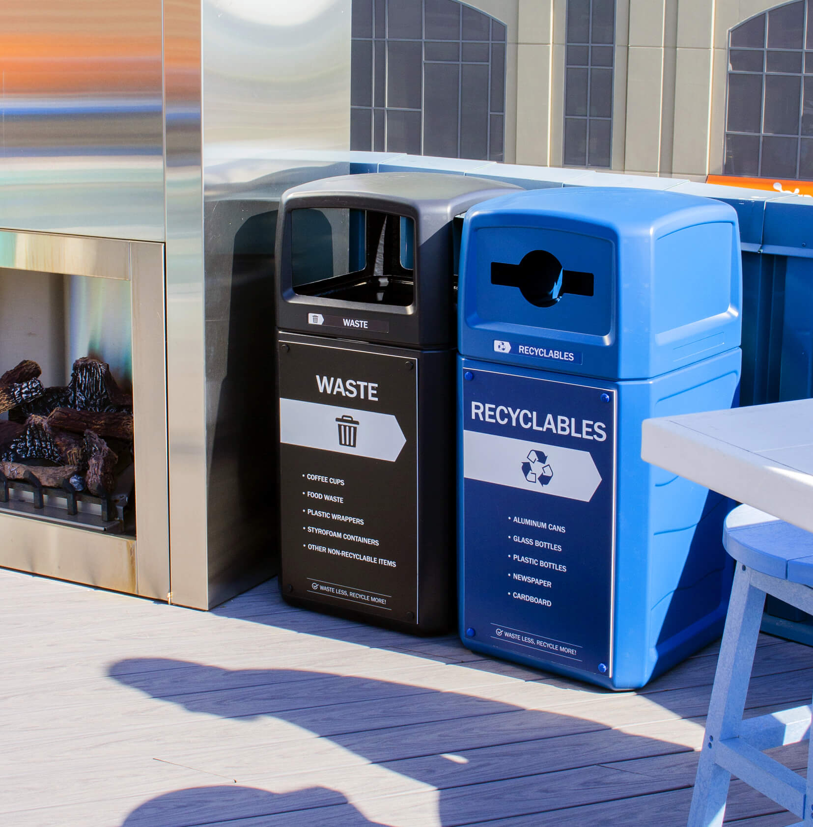 double waste and recyclables bins outside at a bar beside an outdoor fireplace