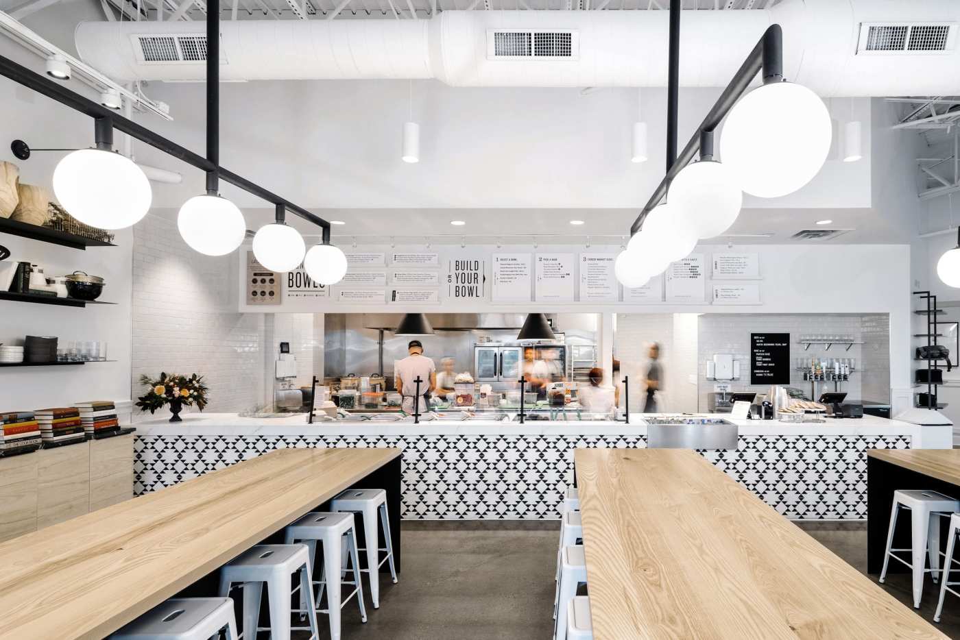 the interior of a restaurant with wooden tables and stools.