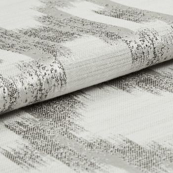 Folded woven fabric with silver metallic horizontal stripes, tightly textured and slightly rolled; resting on a matching fabric surface in soft, neutral studio lighting, close-up detail.