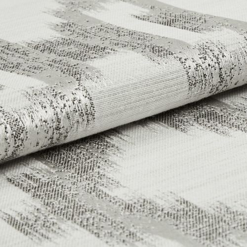 Folded woven fabric with silver metallic horizontal stripes, tightly textured and slightly rolled; resting on a matching fabric surface in soft, neutral studio lighting, close-up detail.