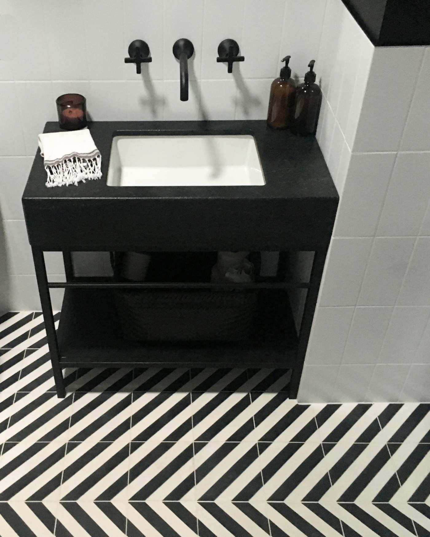 a bathroom with a black and white chevron floor.