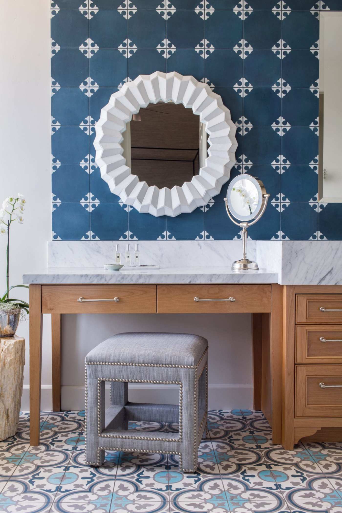 a blue and white bathroom with a vanity and a mirror.