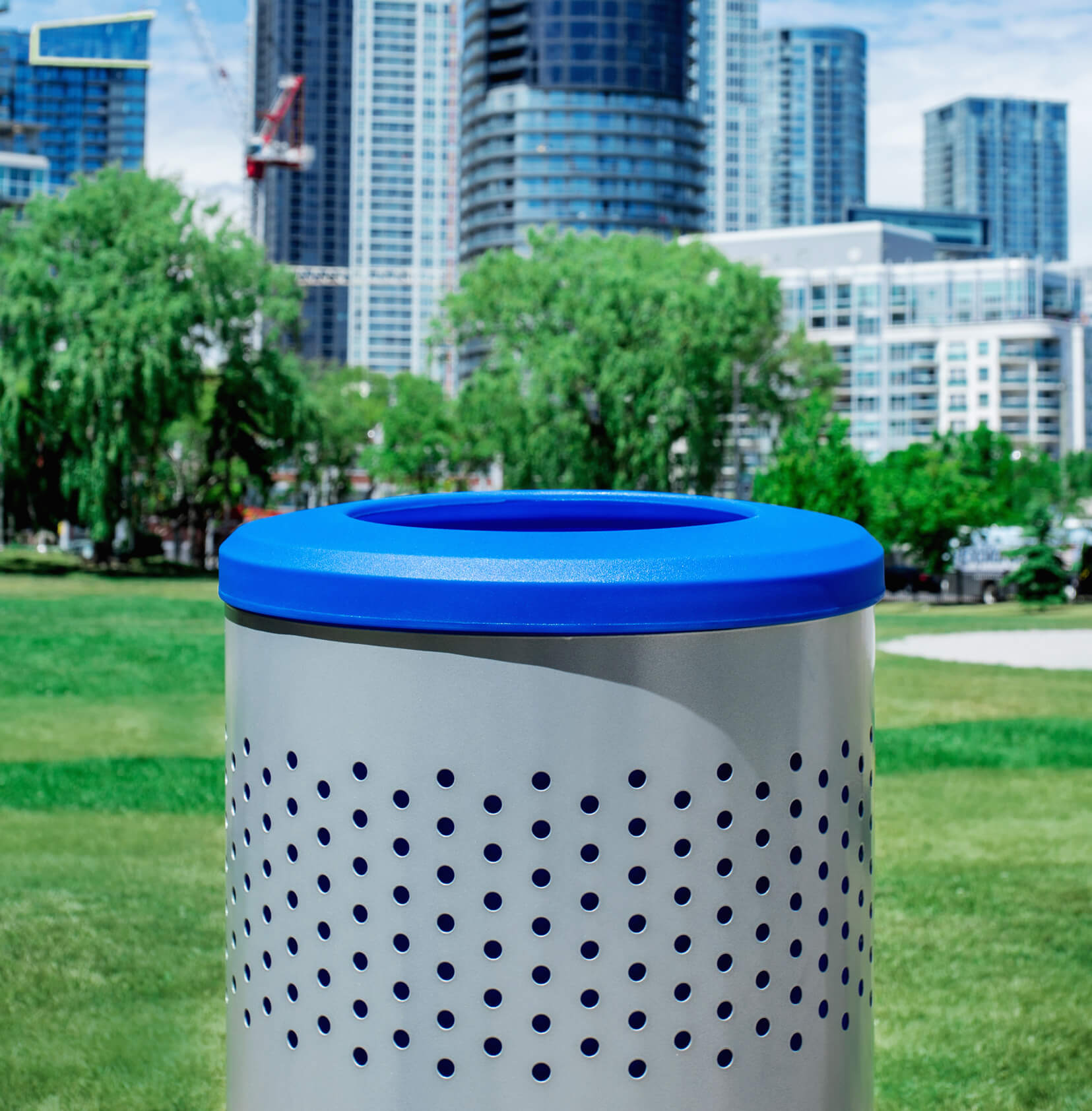 closeup of metal and plastic outdoor recycling container at a city park