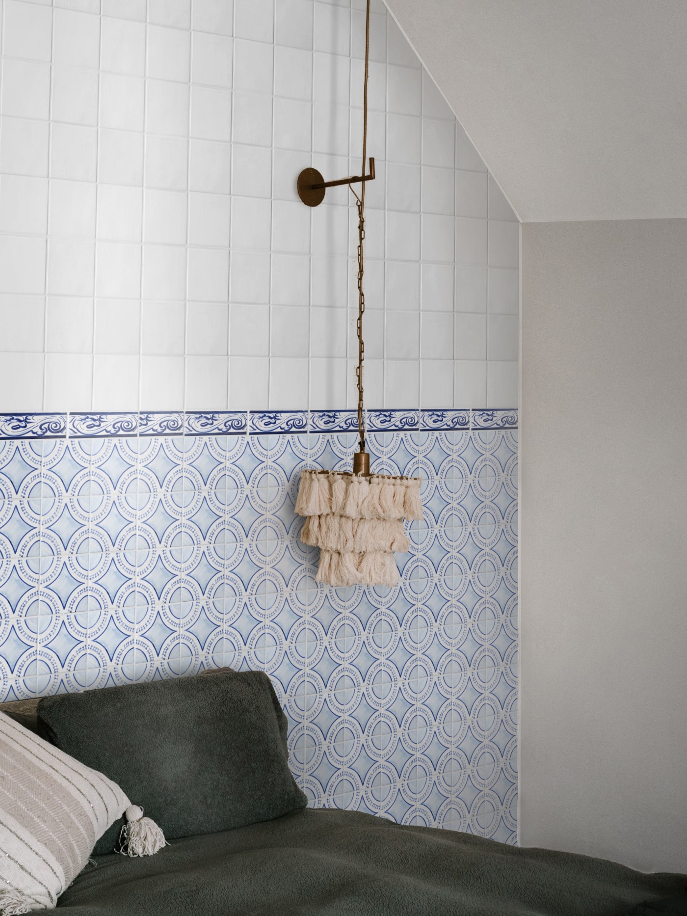 a bed in a room with blue and white tiled walls.