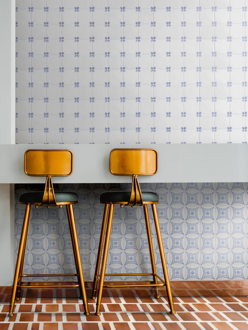 two stools in front of a tiled wall.