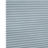 Light-blue cellular (honeycomb) blind, fully lowered with horizontal pleats and hexagonal cells visible at the left edge; blocking light in a close-up view against a white background.