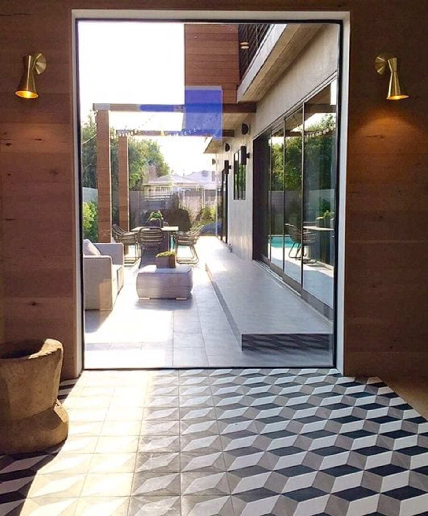 a doorway leading from a patio into a modern home with a tiled floor.