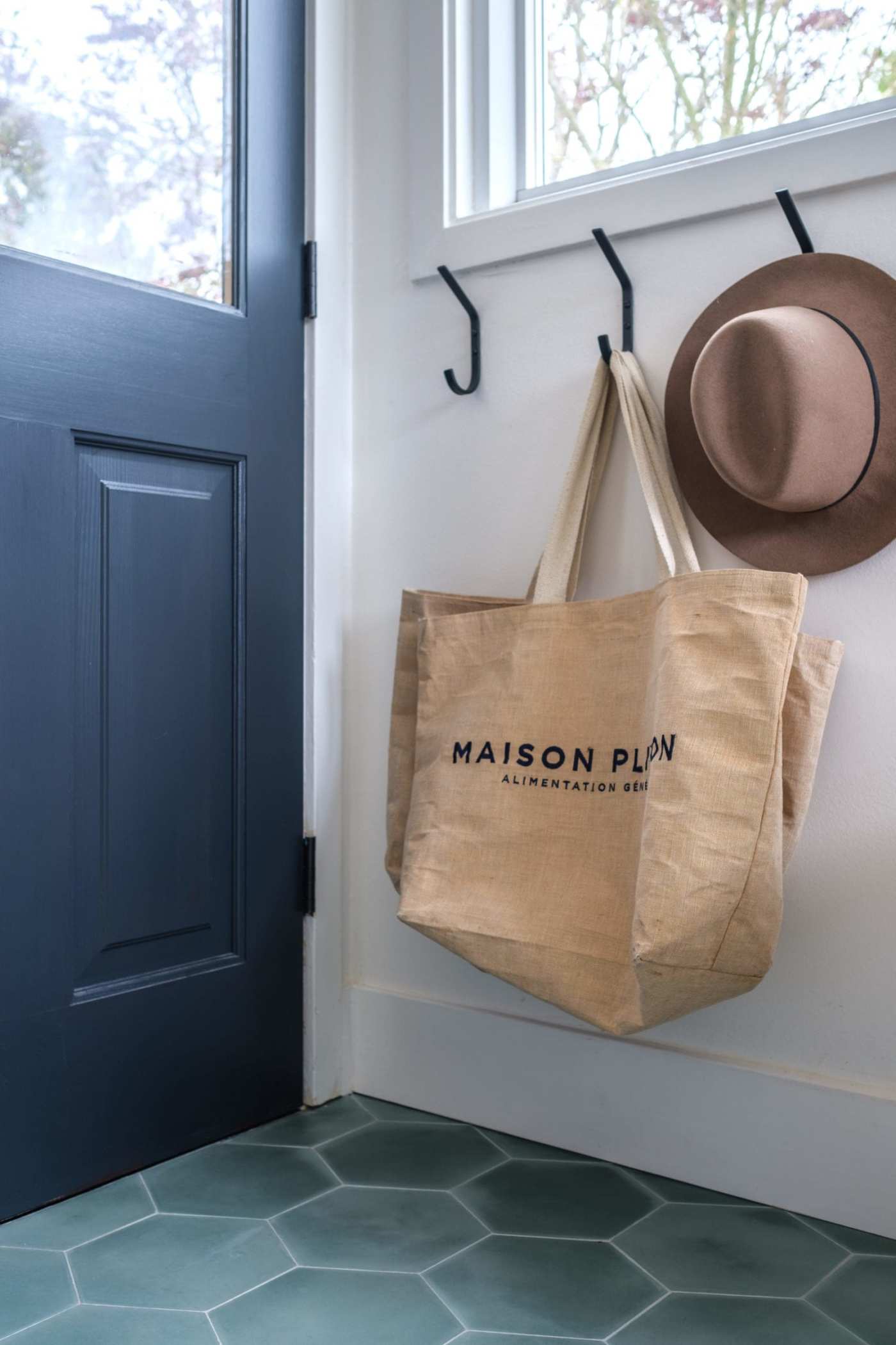 a tote bag hangs next to the door of a home.