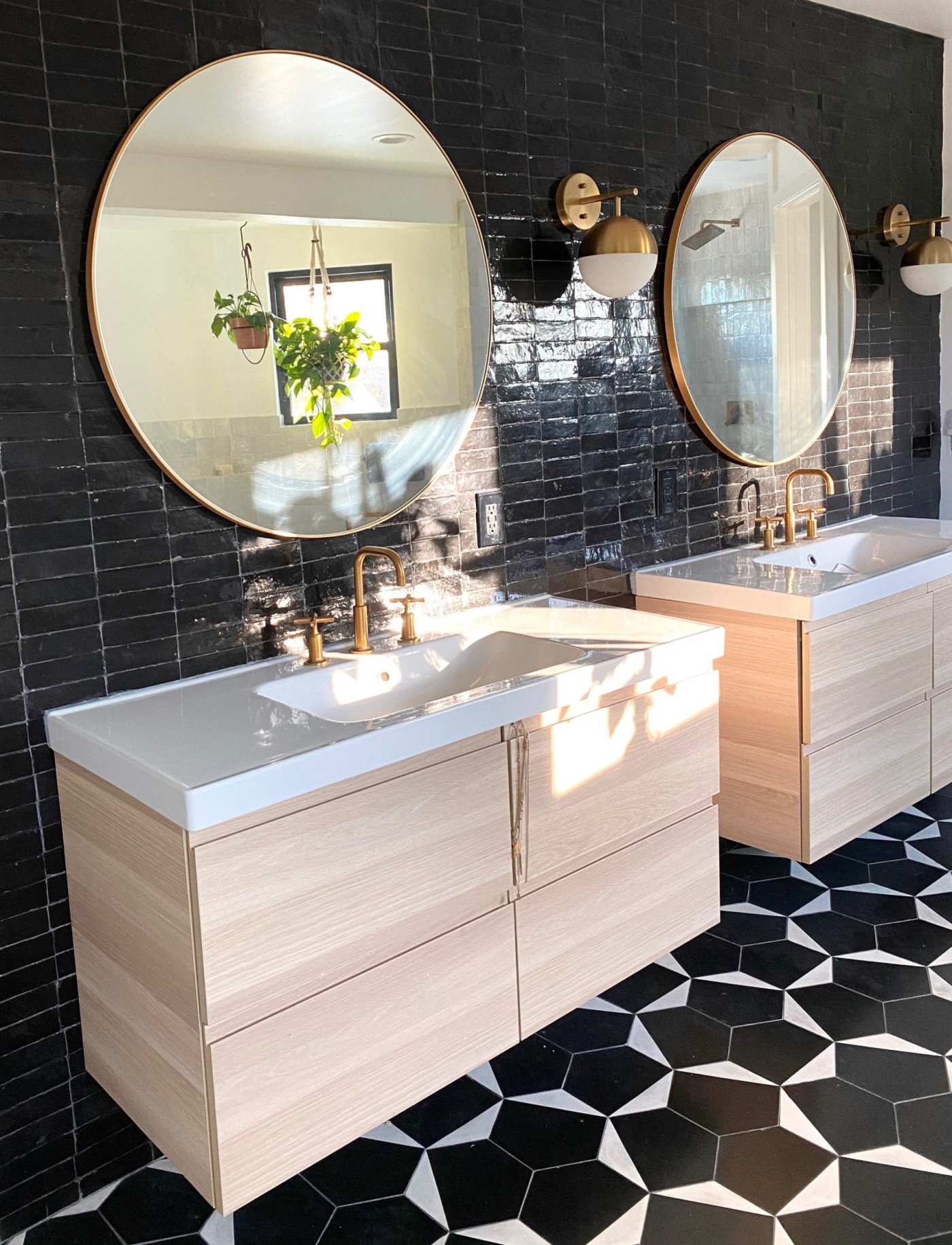 a bathroom with two mirrors and a black and white tiled floor.