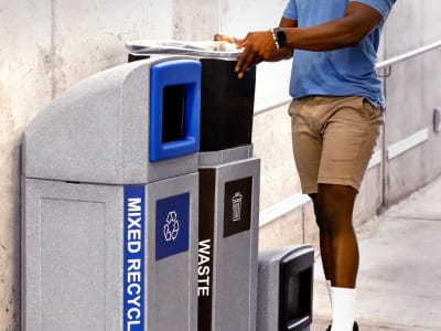 double waste and mixed recycling containers being serviced showing the liner being pulled out in a transit terminal