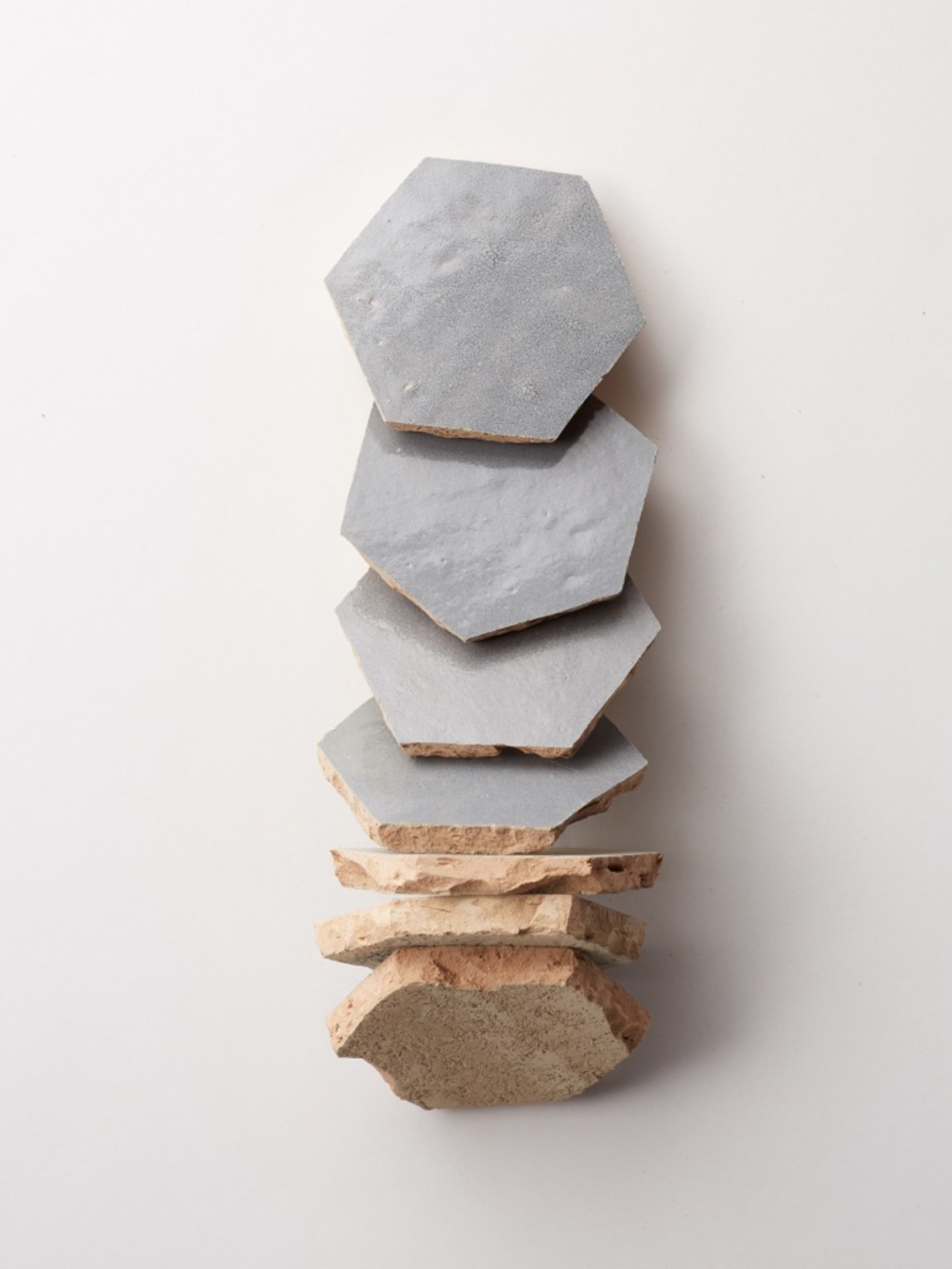 a stack of grey hexagonal tiles on a white background.