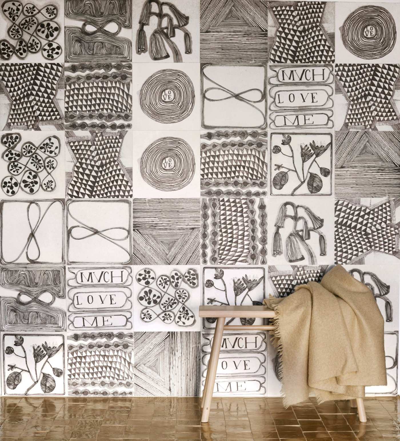 a black and white, patterned tile wall with a bench in front of it.