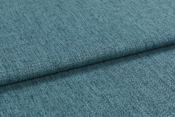 Teal textured upholstery fabric, folded into overlapping layers with visible weave and nap; lying flat as a close-up sample under soft diffuse lighting, showing subtle color variation.