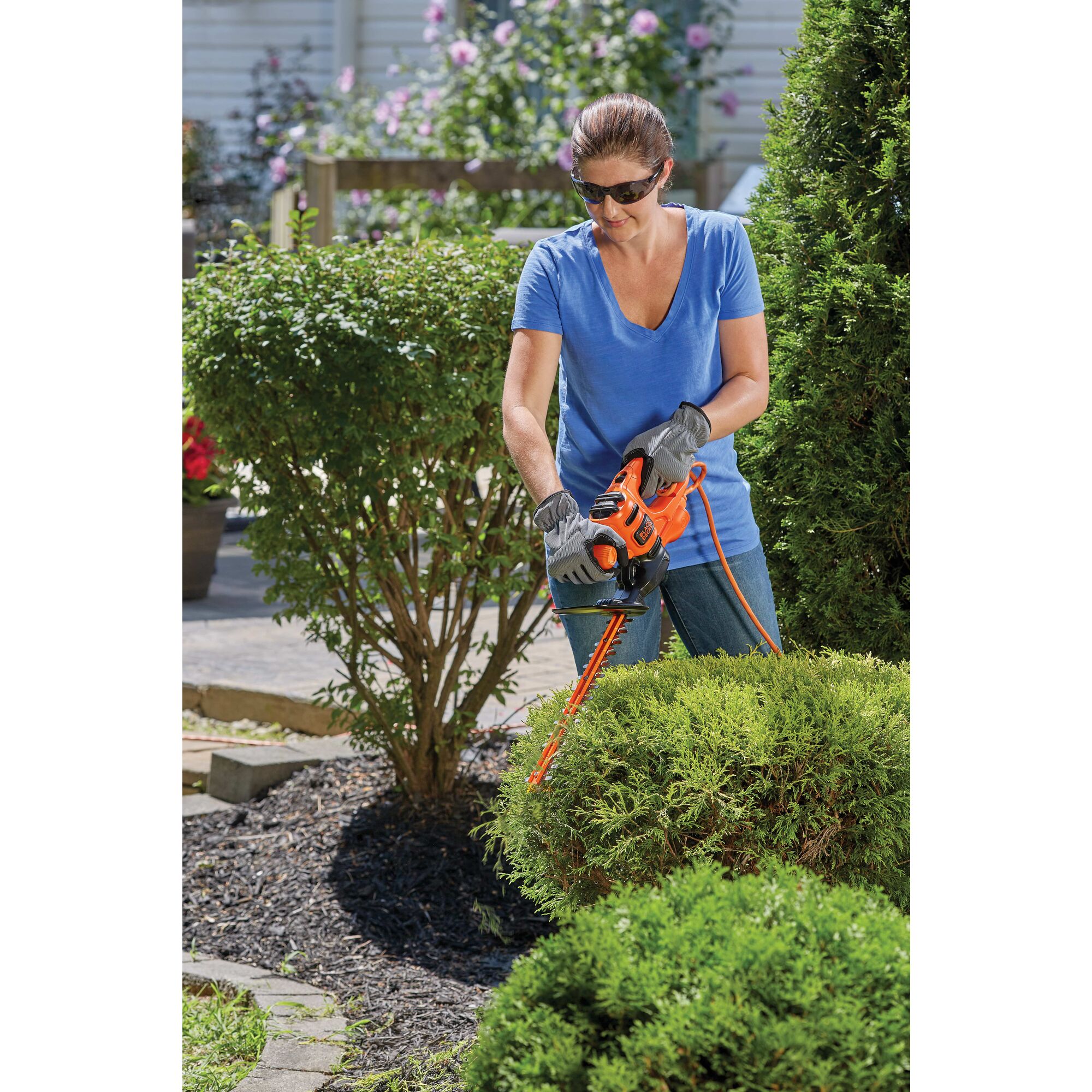 16 inch Electric hedge trimmer being used by a person to trim bushes.