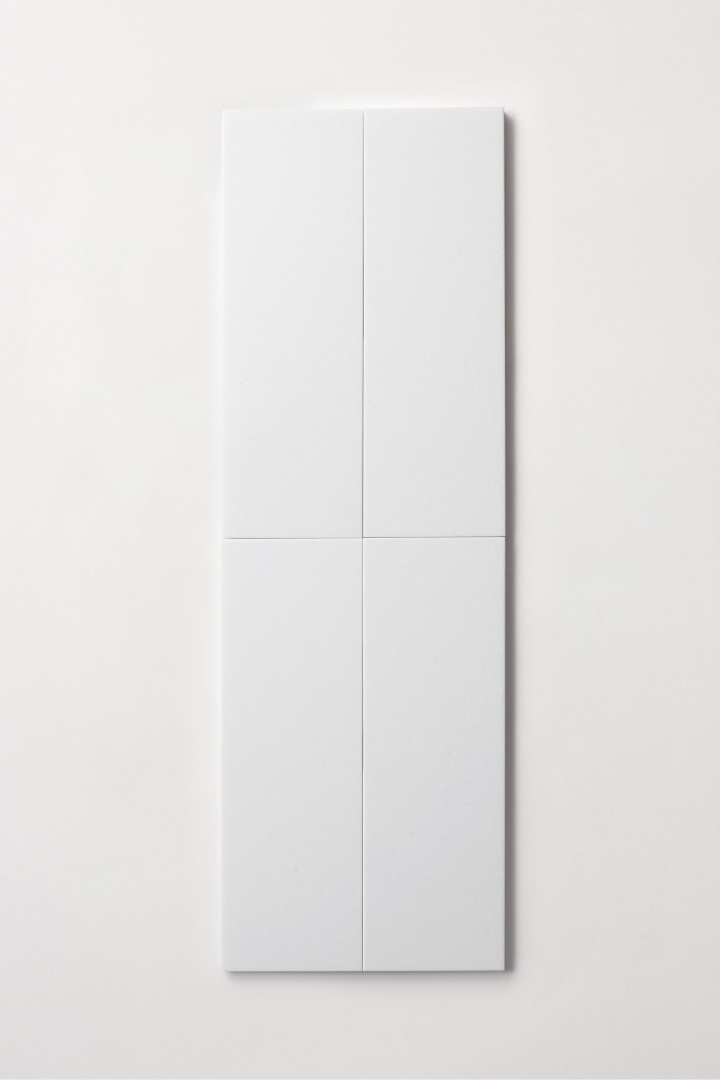 four white rectangle tiles on a white surface.