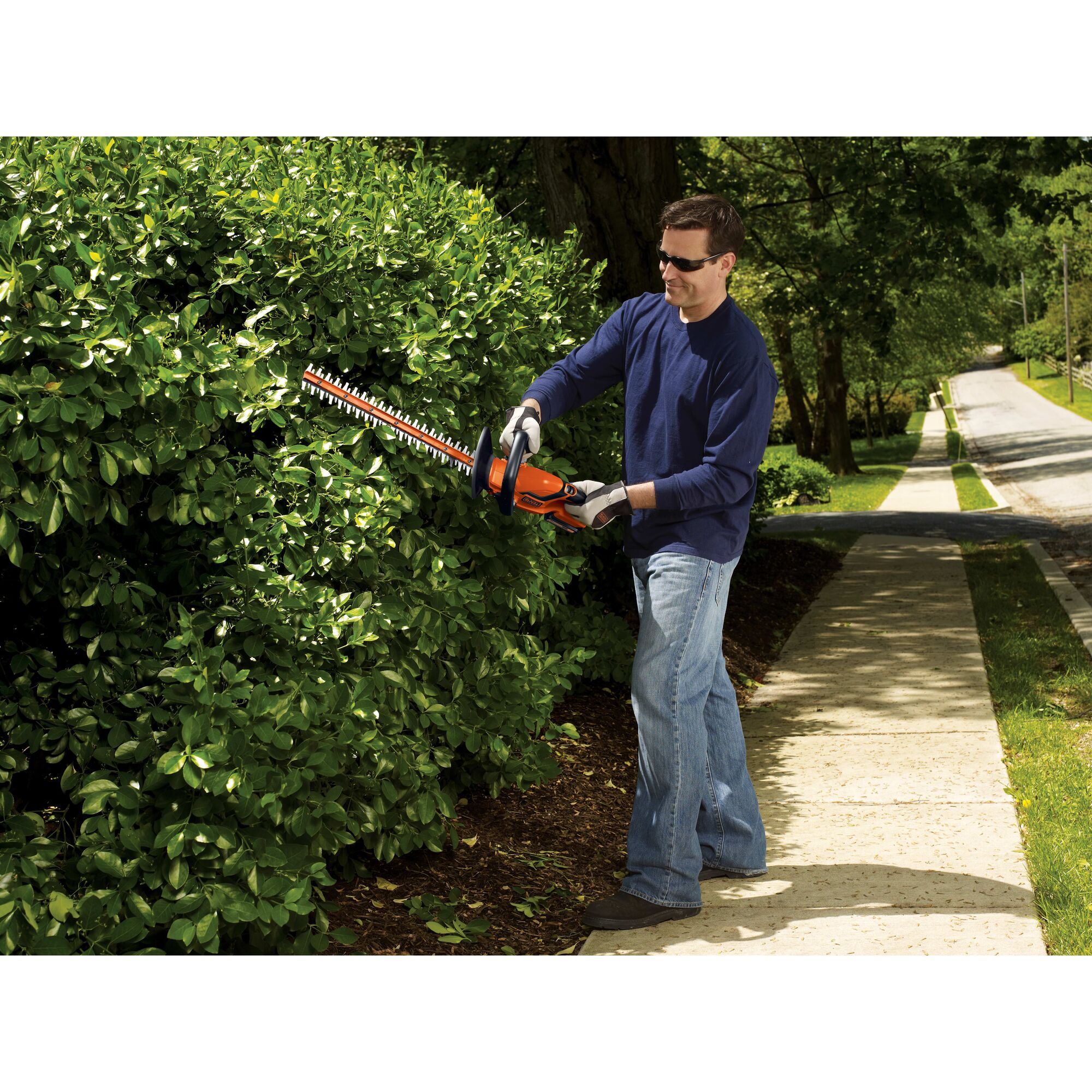 Lithium 22 inch Hedge Trimmer being used by person to trim bushes.