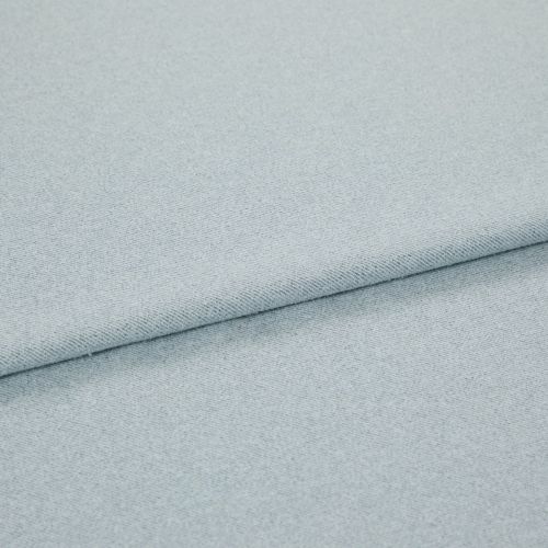 Pale blue woven fabric folded into overlapping layers; diagonal fold runs across frame, showing fine twill-like weave and subtle speckling under soft, even studio lighting.
