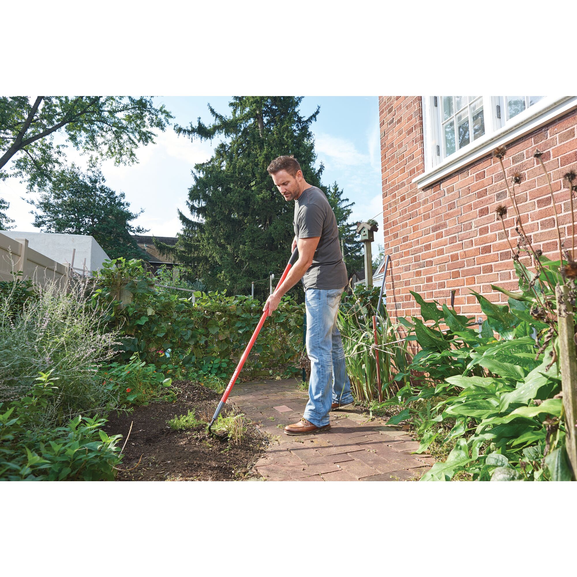 Fiberglass handle garden hoe being used by a person.