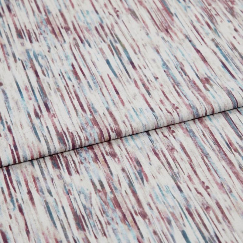 Light-colored textured woven fabric with vertical, streaky maroon and teal lines, folded across itself, lying flat in a close-up studio shot with soft, even lighting.