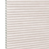 Beige pleated cellular (honeycomb) shade, horizontal ridges with visible open cells at left edge; fully lowered and closed, softly diffusing daylight in a neutral, featureless interior close-up.