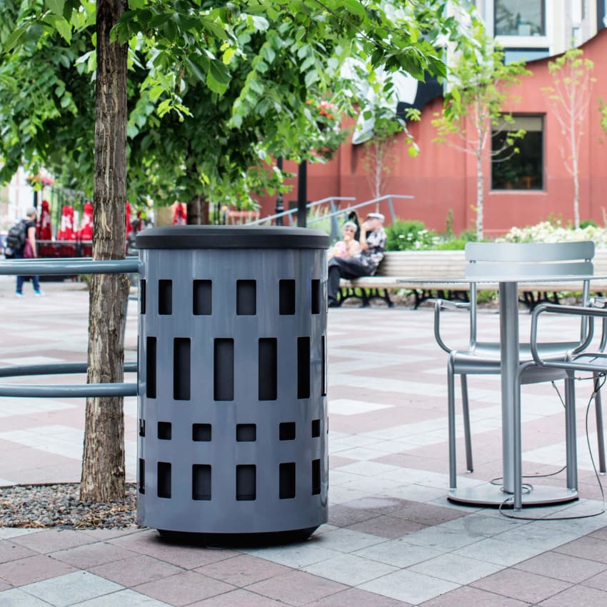 grey powder coated steel outdoor waste container with black plastic lid outside at a city cafe