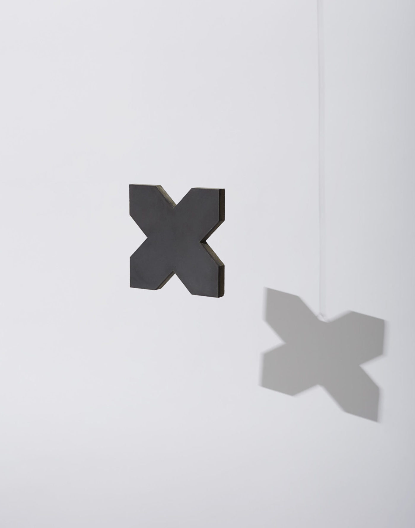 two black and grey cross shaped tiles hanging from the ceiling.