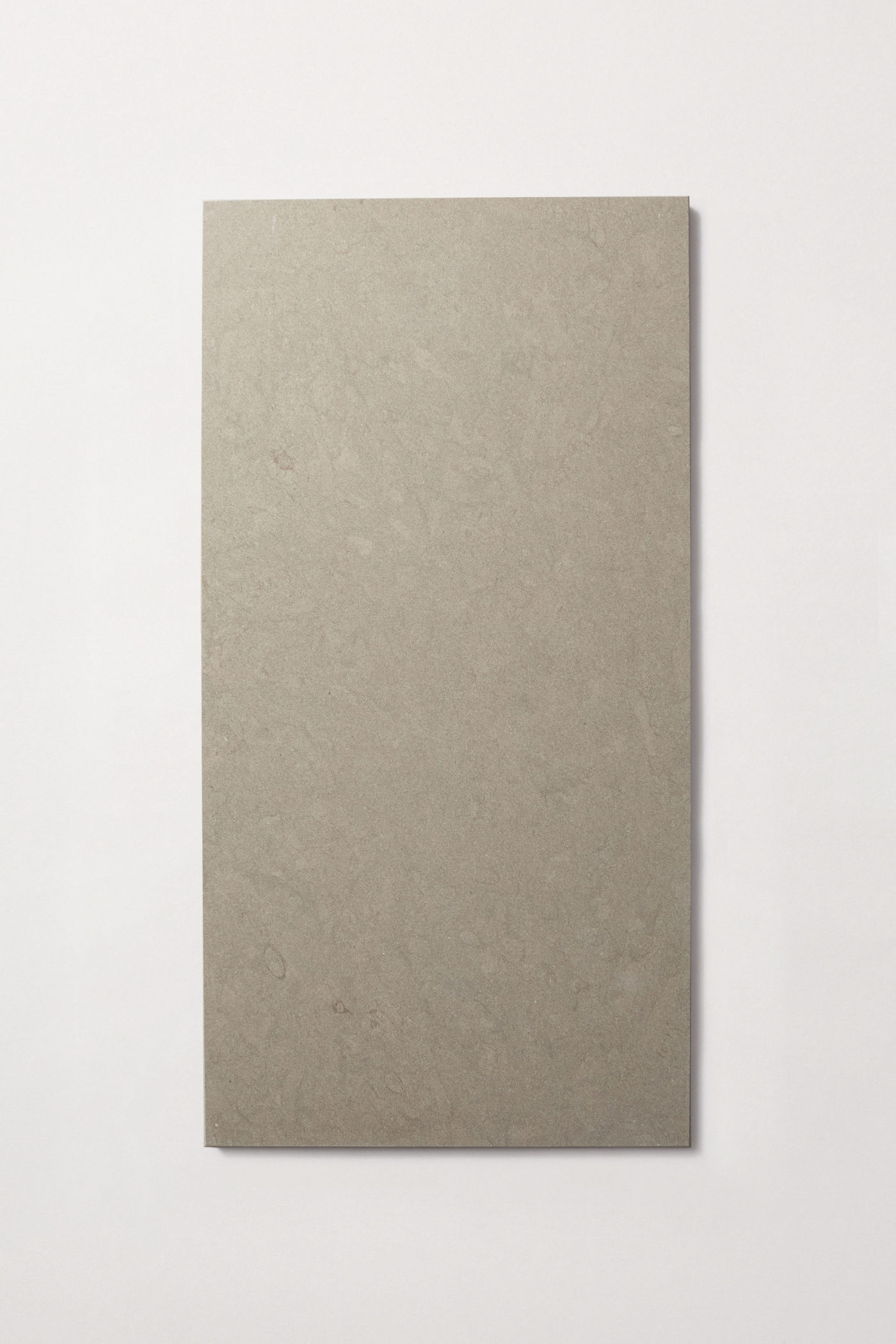 a rectangular grey limestone tile on a white surface.