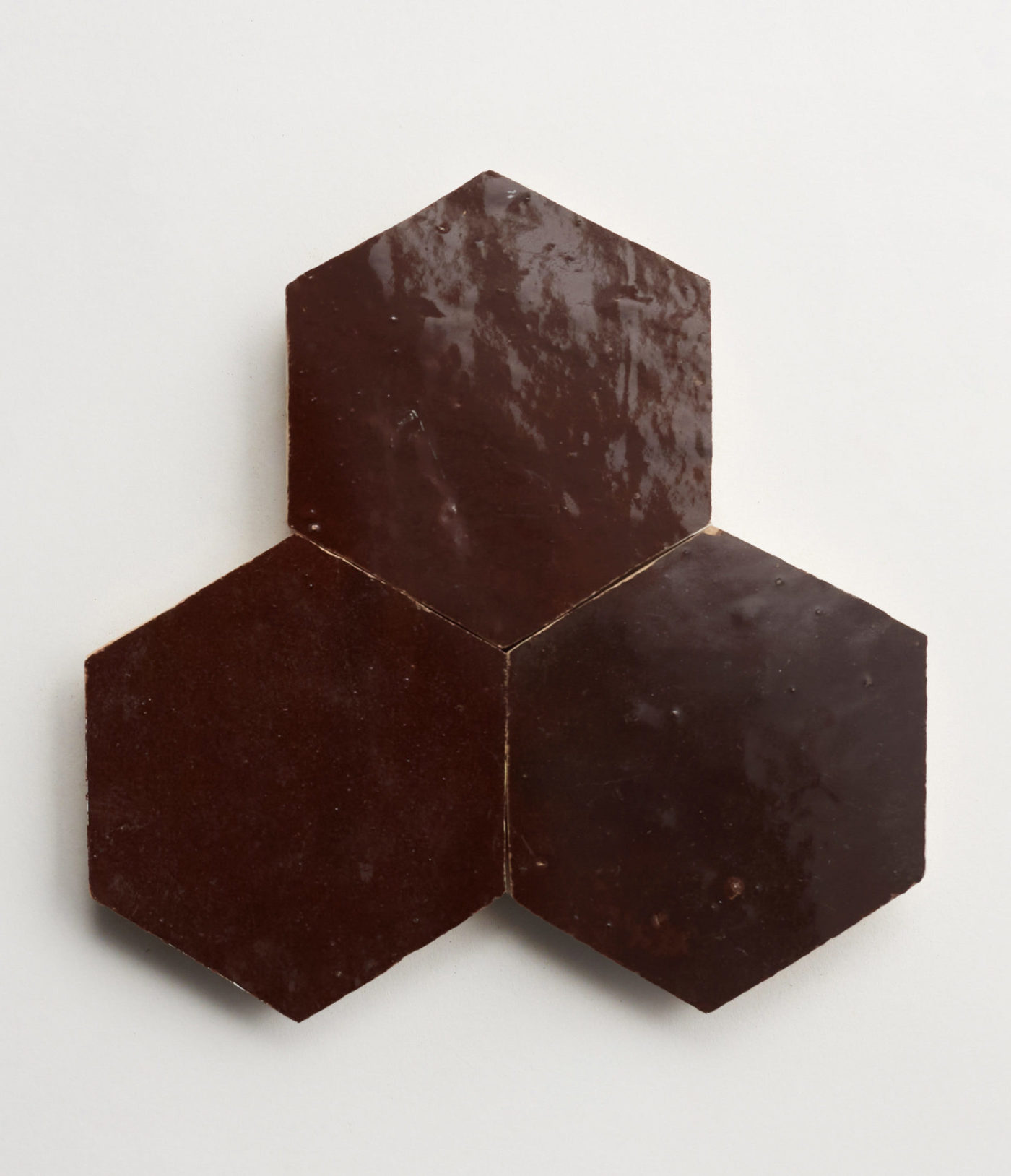 three chocolate hexagon tiles on a white surface.