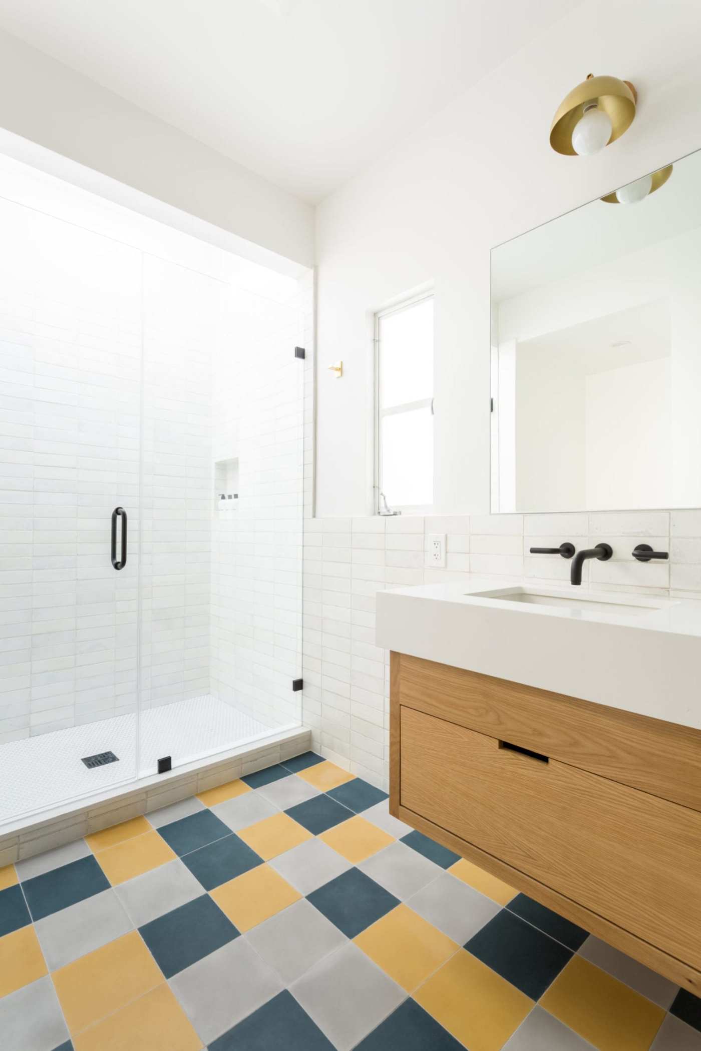 a bathroom with a yellow, grey, and blue checkered floor.